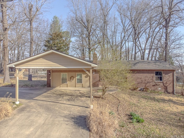 view of front of property featuring brick siding, an attached carport, and driveway