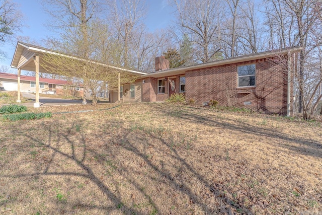 ranch-style home with crawl space, brick siding, a front yard, and a chimney