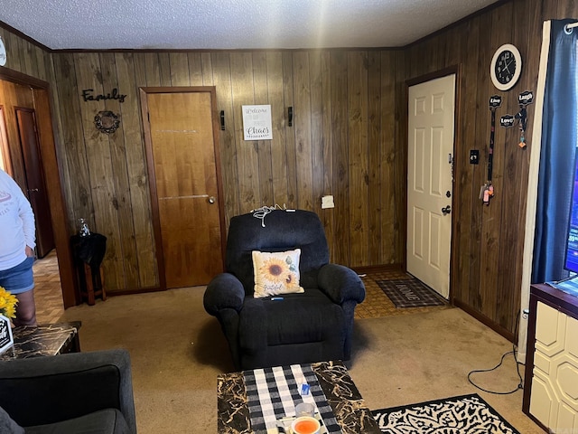 carpeted entrance foyer with wooden walls, ornamental molding, and a textured ceiling