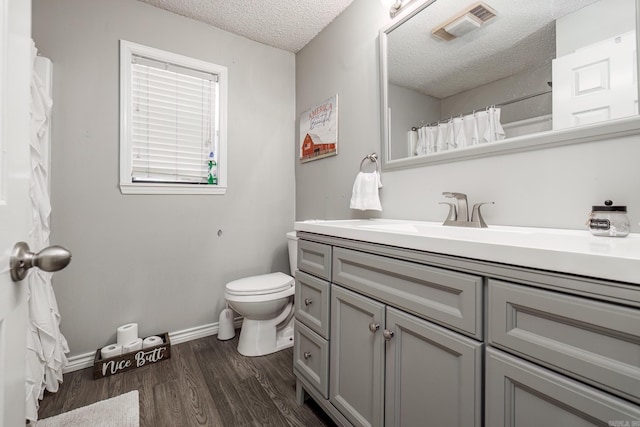 2304 Forrest Park Dr, Arkadelphia, AR 71923 - bathroom featuring vanity, wood finished floors, visible vents, a textured ceiling, and toilet
