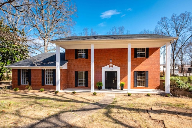 neoclassical / greek revival house with brick siding and a porch