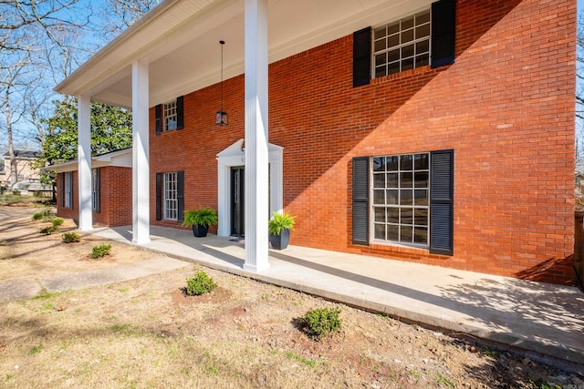 exterior space with brick siding and a porch