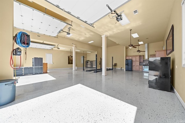 1601 Marion Anderson Rd, Hot Springs, AR 71913 - garage with a ceiling fan, visible vents, baseboards, a garage door opener, and black refrigerator with ice dispenser