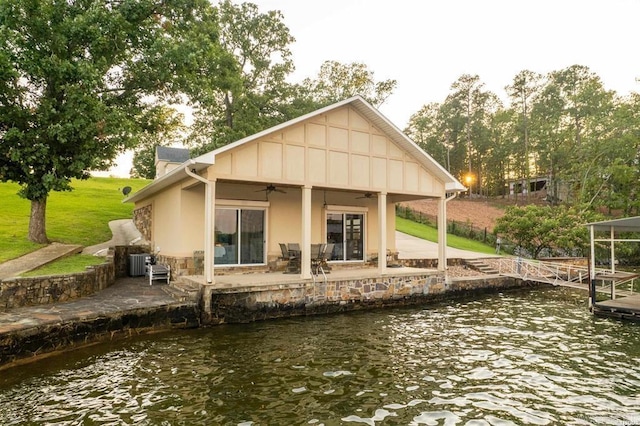 1601 Marion Anderson Rd, Hot Springs, AR 71913 - rear view of house featuring a ceiling fan, a water view, stone siding, a patio area, and a lawn