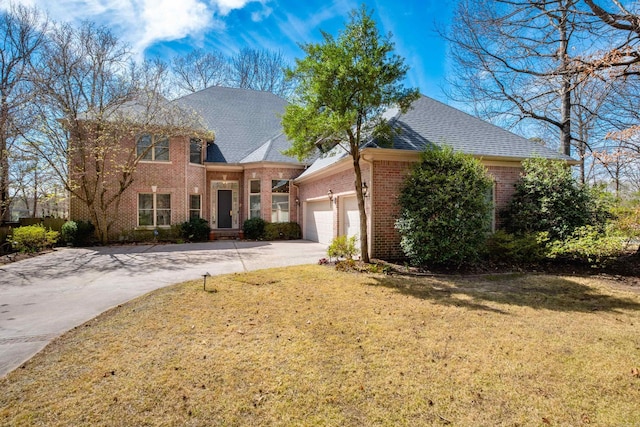 traditional home with roof with shingles, an attached garage, concrete driveway, a front lawn, and brick siding