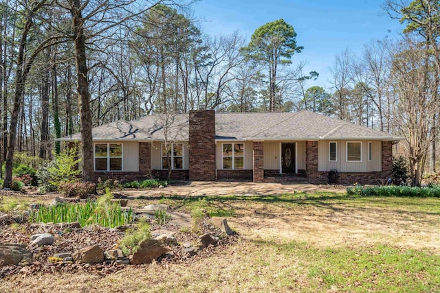 ranch-style house featuring brick siding and a chimney