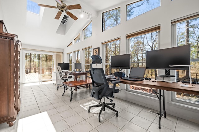 home office with visible vents, ceiling fan, light tile patterned floors, rail lighting, and high vaulted ceiling