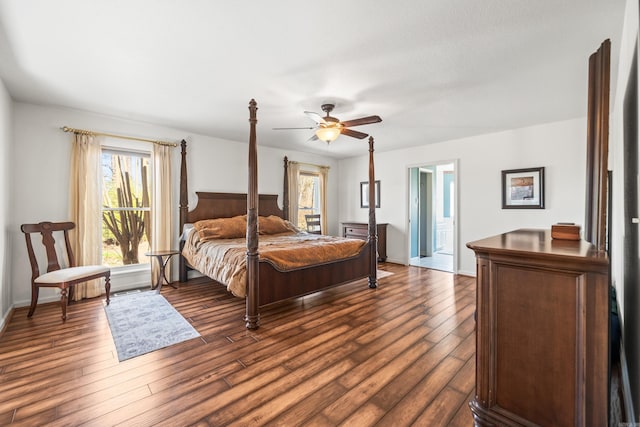bedroom with ceiling fan, ensuite bathroom, baseboards, and dark wood-style flooring