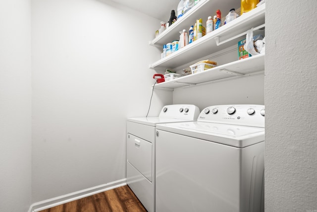 laundry area featuring dark wood finished floors, laundry area, baseboards, and washing machine and clothes dryer