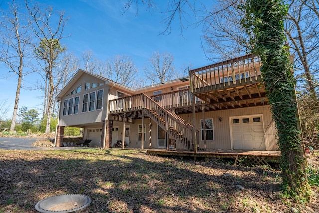 rear view of property featuring stairway, an attached garage, and a deck