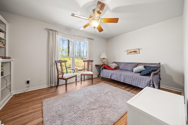 living room with light wood-style flooring, baseboards, and ceiling fan