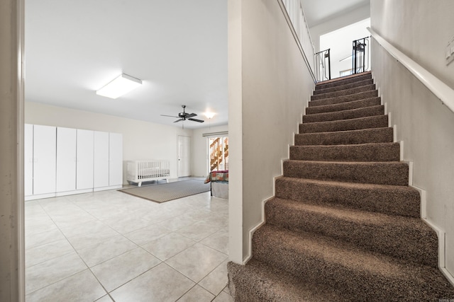 stairs with tile patterned floors and ceiling fan