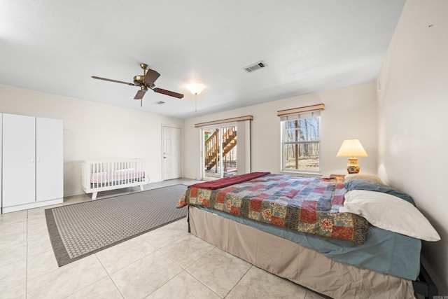 bedroom with light tile patterned floors, visible vents, and a ceiling fan