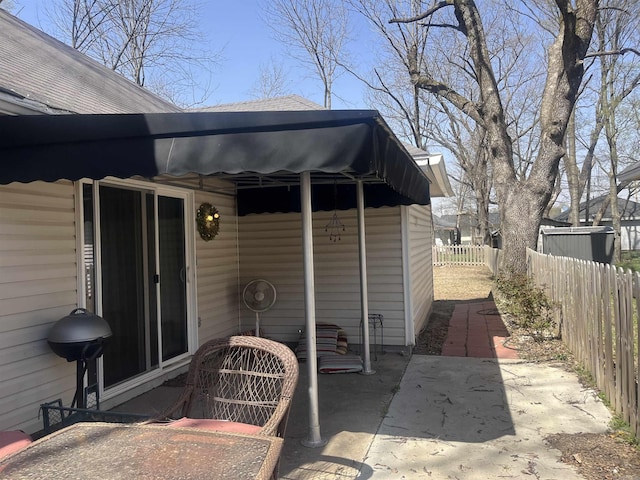 view of patio featuring a grill and fence