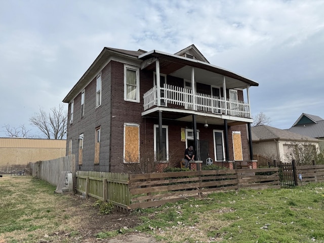 view of front of home featuring a fenced front yard, a balcony, and a front yard