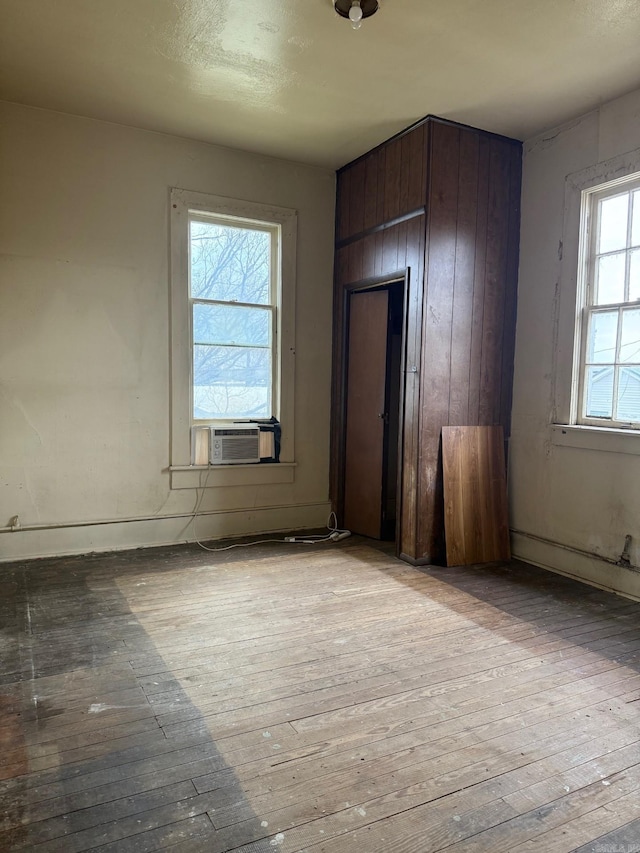 unfurnished room with cooling unit and wood-type flooring