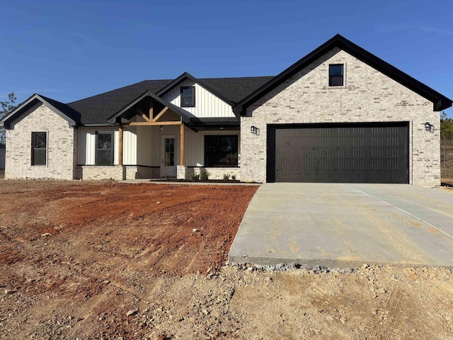 modern inspired farmhouse featuring brick siding, board and batten siding, driveway, and a garage