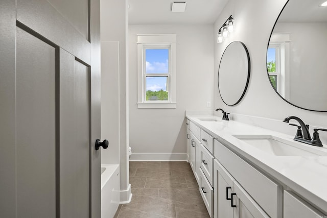 full bath with double vanity, baseboards, and toilet