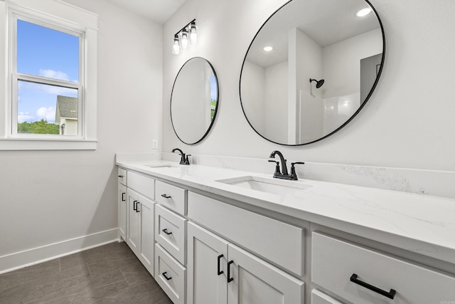 bathroom featuring baseboards and double vanity