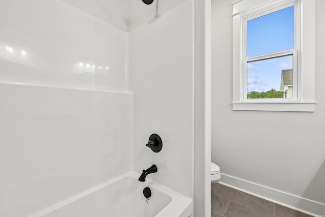 full bath featuring tub / shower combination, toilet, baseboards, and tile patterned flooring