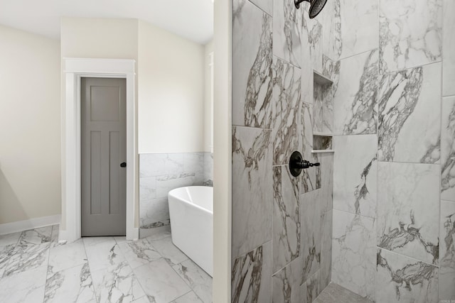 full bath featuring a soaking tub, tiled shower, tile walls, marble finish floors, and a wainscoted wall