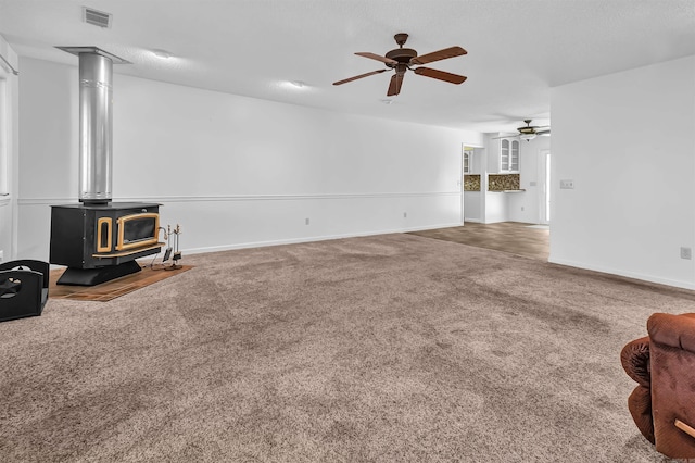 120 Lisa Blvd, Greers Ferry, AR 72067 - living area with visible vents, a ceiling fan, carpet flooring, baseboards, and a wood stove