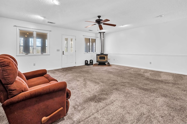 120 Lisa Blvd, Greers Ferry, AR 72067 - living room with visible vents, ceiling fan, carpet flooring, a wood stove, and a textured ceiling