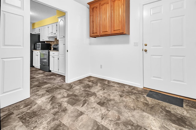 120 Lisa Blvd, Greers Ferry, AR 72067 - kitchen with under cabinet range hood, stainless steel microwave, range with electric stovetop, refrigerator, and baseboards