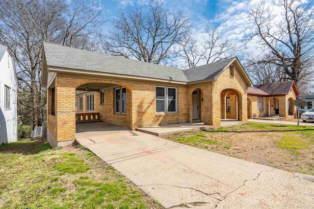 view of front of house featuring an attached carport, concrete driveway, and brick siding