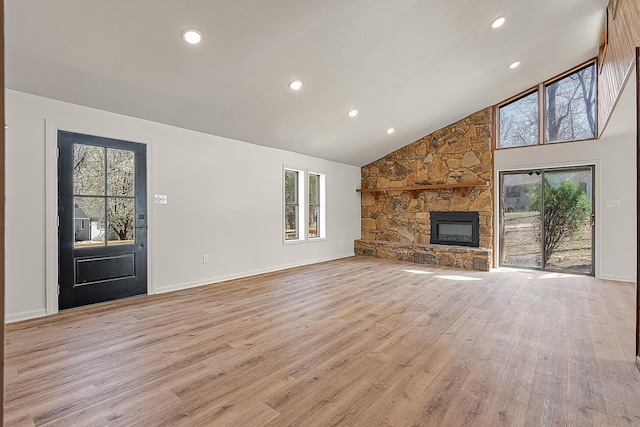 unfurnished living room featuring baseboards, recessed lighting, light wood-style flooring, a fireplace, and high vaulted ceiling