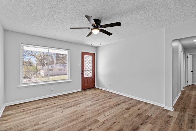 foyer featuring visible vents, a ceiling fan, a textured ceiling, wood finished floors, and baseboards