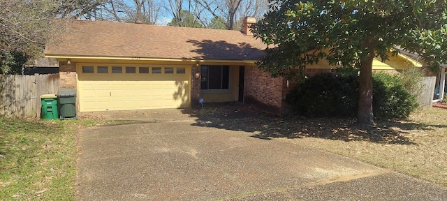 ranch-style home with fence, a chimney, concrete driveway, a garage, and brick siding