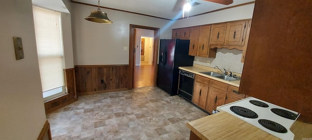 kitchen featuring a wainscoted wall, ceiling fan, a sink, black appliances, and light countertops