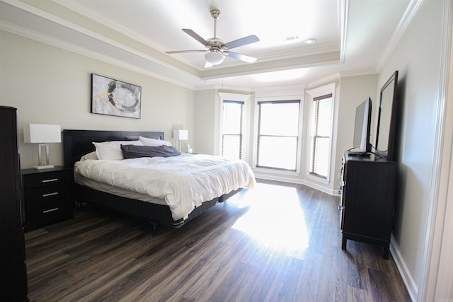 bedroom with visible vents, crown molding, a raised ceiling, and dark wood-style flooring
