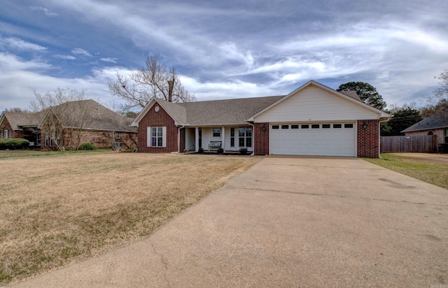 single story home with brick siding, fence, concrete driveway, a front yard, and an attached garage