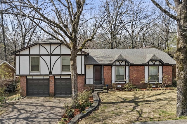 tudor home with aphalt driveway, brick siding, roof with shingles, and an attached garage