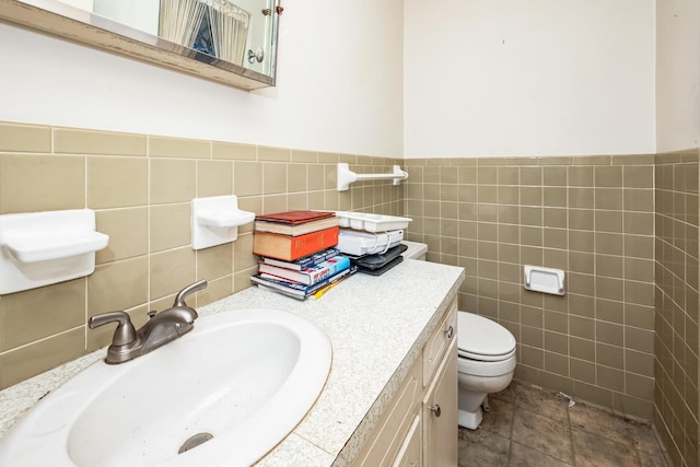 bathroom with a wainscoted wall, toilet, tile walls, and vanity