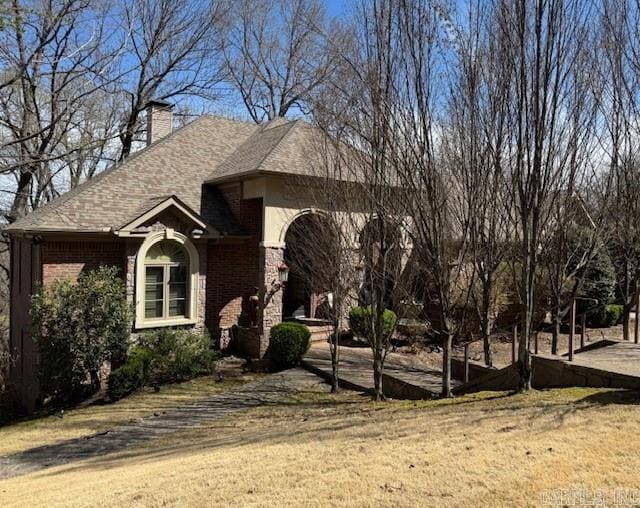 33 Greathouse Bend Dr, Little Rock, AR 72207 - view of front facade with brick siding, a front yard, roof with shingles, and a chimney