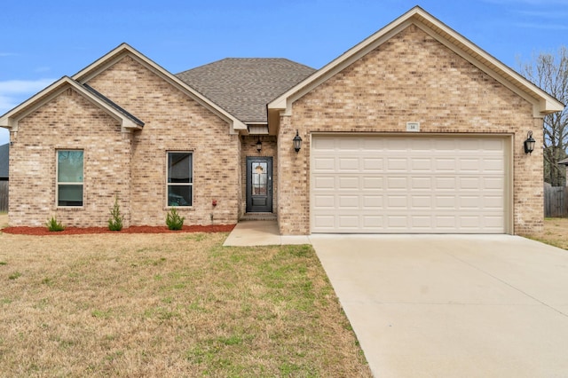 single story home with roof with shingles, concrete driveway, a front yard, a garage, and brick siding