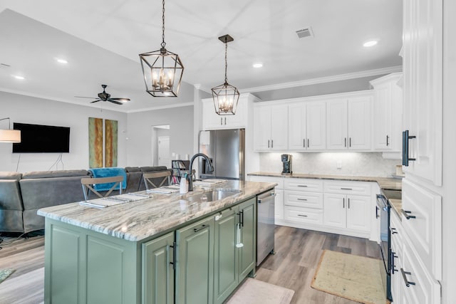 kitchen featuring visible vents, white cabinets, stainless steel appliances, and ceiling fan with notable chandelier