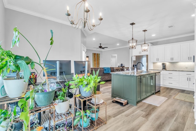 kitchen featuring open floor plan, ceiling fan with notable chandelier, stainless steel dishwasher, white cabinetry, and a sink