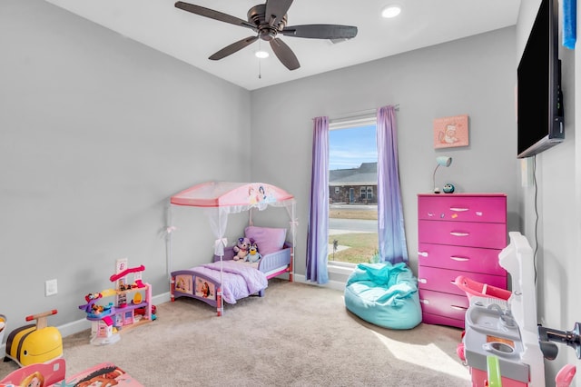 carpeted bedroom with ceiling fan and baseboards