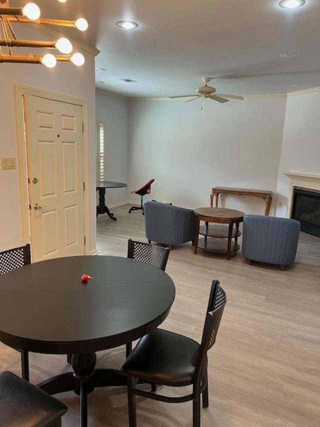 4000 Ridgepointe Cv, Jonesboro, AR 72404 - dining space featuring recessed lighting, ornamental molding, ceiling fan, a glass covered fireplace, and light wood-type flooring