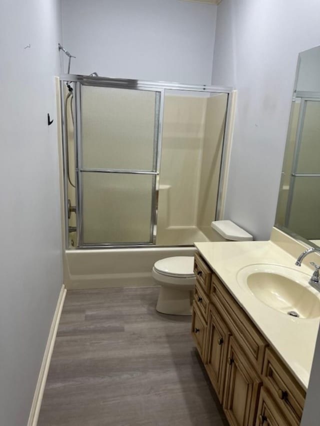 4000 Ridgepointe Cv, Jonesboro, AR 72404 - full bathroom with baseboards, toilet, wood finished floors, shower / bath combination with glass door, and vanity