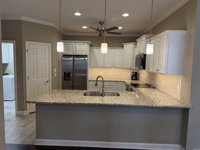 kitchen with ceiling fan, light stone countertops, washer / dryer, appliances with stainless steel finishes, and a sink