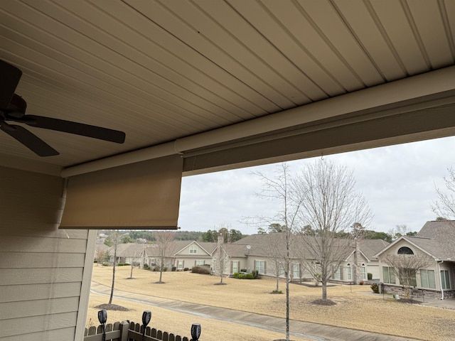 exterior details featuring fence, a ceiling fan, and a residential view