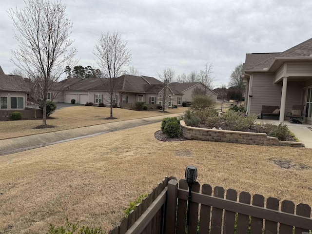 view of yard with a patio, fence, and a residential view