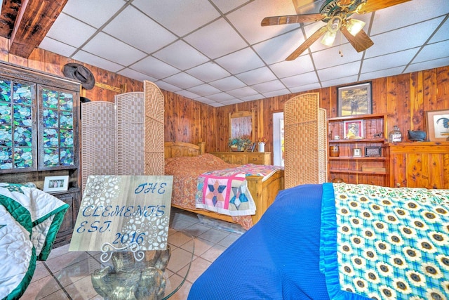 tiled bedroom with a drop ceiling and wood walls