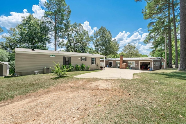 back of house featuring cooling unit, a lawn, and a patio area