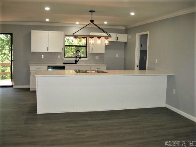 kitchen featuring dark wood-style floors, white cabinets, light countertops, and crown molding